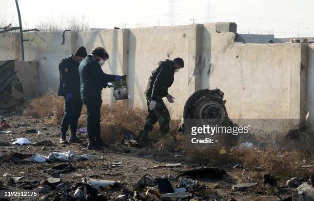 Rescue teams work amidst debris after a Ukrainian plane carrying 176 passengers crashed near Imam Khomeini airport in the Iranian capital Tehran...