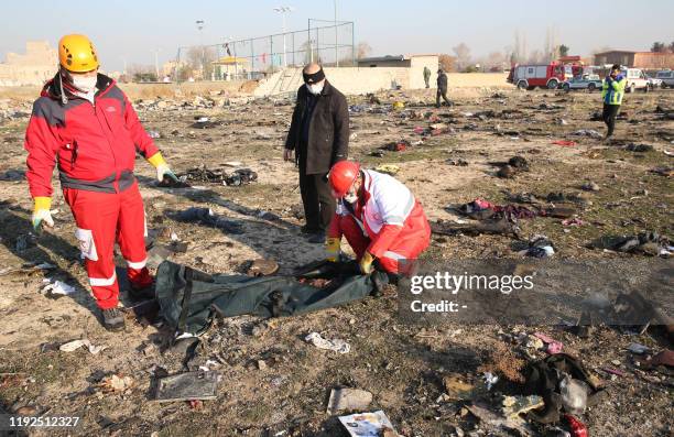 Graphic content / Rescue teams recover a body after a Ukrainian plane carrying 176 passengers crashed near Imam Khomeini airport in the Iranian...