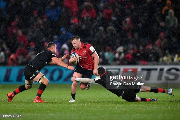 Rory Scannell of Munster is tackled by Ben Earl and Ben Spencer of Saracens during the Heineken Champions Cup Round 3 match between Munster Rugby and...