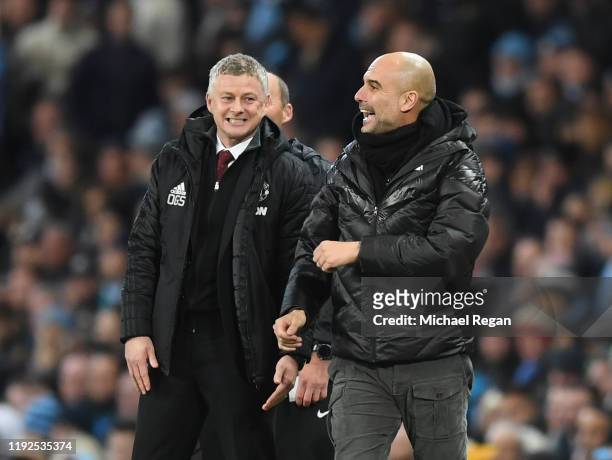 Ole Gunnar Solskjaer, Manager of Manchester United speaks with Pep Guardiola, Manager of Manchester City during the Premier League match between...