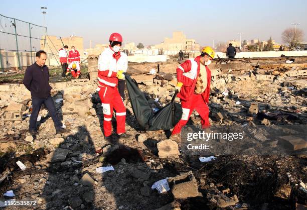 Graphic content / Rescue teams recover a body after a Ukrainian plane carrying 176 passengers crashed near Imam Khomeini airport in the Iranian...