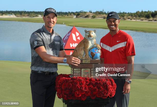 Tiger Woods of the United States the tournament host presents Henrik Stenson of Sweden with the trophy after the final round of the 2019 Hero World...