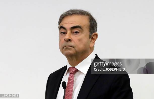 Former Renault-Nissan boss Carlos Ghosn looks on before addressing a large crowd of journalists on his reasons for dodging trial in Japan, where he...