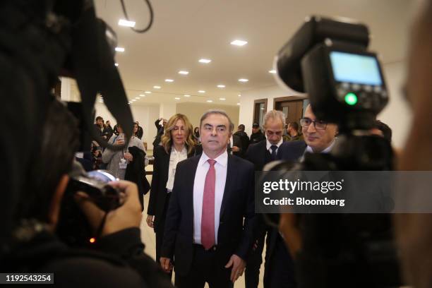 Carlos Ghosn, former chief executive officer of Nissan Motor Co. And Renault SA, and his wife Carole, left, arrive for a news conference at the...