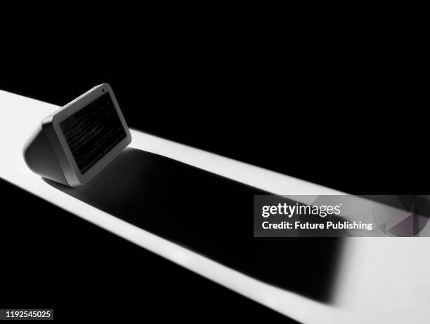 An Amazon Echo Show 5 smart display casting a sinister shadow, to represent issues of privacy and security, taken on December 12, 2019.