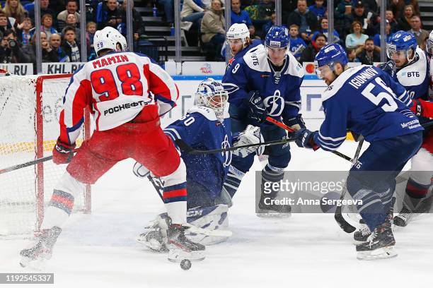 Ivan Bocharov of Dynamo Moscow makes a save against Maxim Mamin of CSKA Moscow during the first period of the Kontinental Hockey League between...