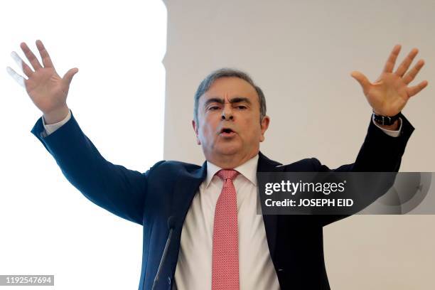 Former Renault-Nissan boss Carlos Ghosn gestures as he addresses a large crowd of journalists on his reasons for dodging trial in Japan, where he is...