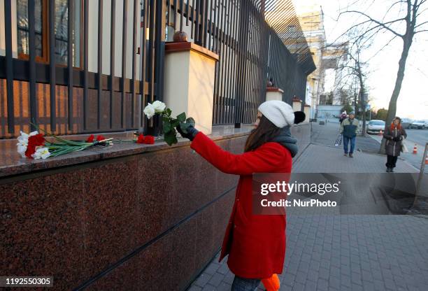 An young woman lays flowers in memory of victims of Ukrainian 737-800 plane that crashed in Iran, outside the embassy of Canada in Kyiv, Ukraine, on...