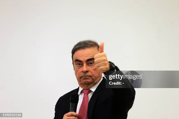 Former Renault-Nissan boss Carlos Ghosn gestures as he addresses a large crowd of journalists on his reasons for dodging trial in Japan, where he is...