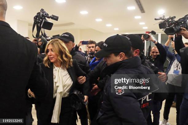 Carole Ghosn, wife of Carlos Ghosn, former chief executive officer of Nissan Motor Co. And Renault SA, departs with the help of security staff after...