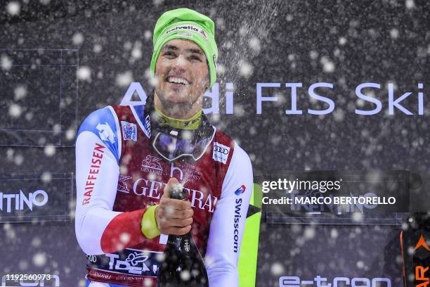 Race winner Switzerland's Daniel Yule sprays champagne as he celebrates on the podium after competing in the FIS Alpine Ski World Cup's Men's Slalom...