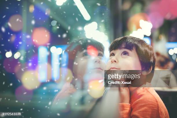 little boy looking out of the window - christmas future stock pictures, royalty-free photos & images