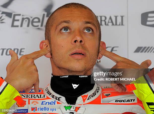 Italy's Valentino Rossi of the Ducati team puts on earplugs before the first free practice session of the Moto Grand Prix at the Sachsenring Circuit...