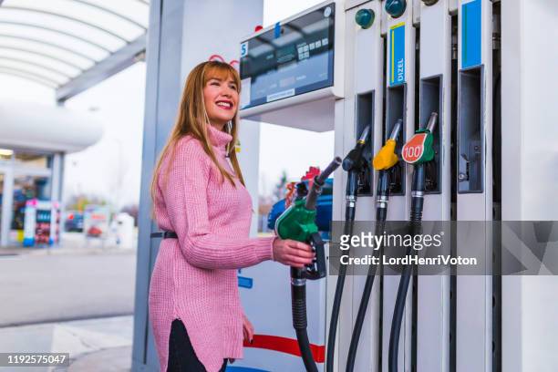 woman holding a fuel pump - gasoline pouring stock pictures, royalty-free photos & images