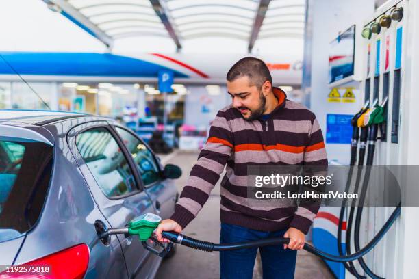 hombre en la gasolinera - gas prices fotografías e imágenes de stock