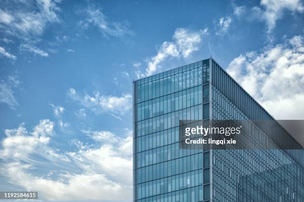 building glass curtain wall under blue sky and white clouds - torre struttura edile foto e immagini stock