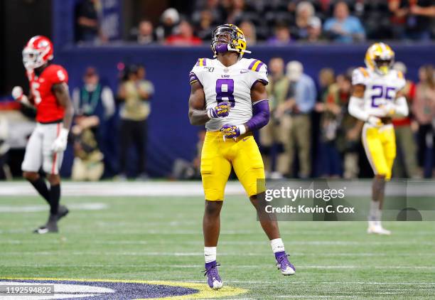 Patrick Queen of the LSU Tigers celebrates in the second half against the Georgia Bulldogs during the SEC Championship game at Mercedes-Benz Stadium...