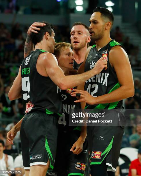 Ben Madgen of the Phoenix celebrates with teammates Kyle Adnam, Mitchell Creek and Tai Wesley during the round 10 NBL match between the South East...