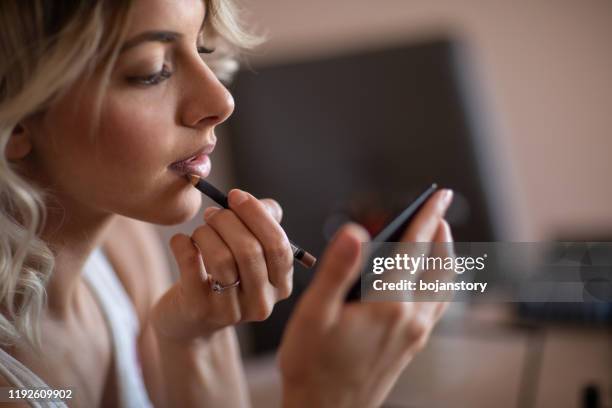 beautiful young woman applying lips contour - lip liner stock pictures, royalty-free photos & images