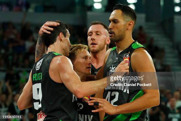 Ben Madgen of the Phoenix celebrates with teammates Kyle Adnam, Mitchell Creek and Tai Wesley during the round 10 NBL match between the South East...