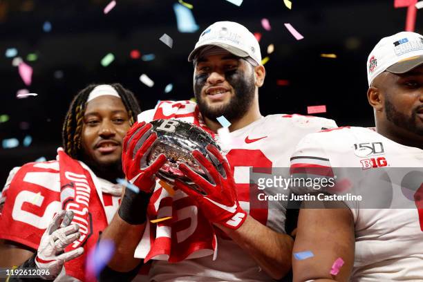 Branden Bowen of the Ohio State Buckeyes holds the Big Ten Championship trophy after a win over the Wisconsin Badgers at Lucas Oil Stadium on...