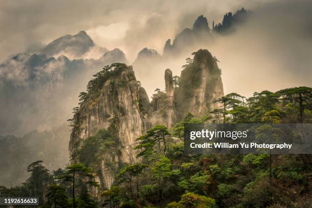 mystic clouds and fogs shroud the mountain peaks of mt. huangshan - huangshan mountain range anhui province china stock pictures, royalty-free photos & images