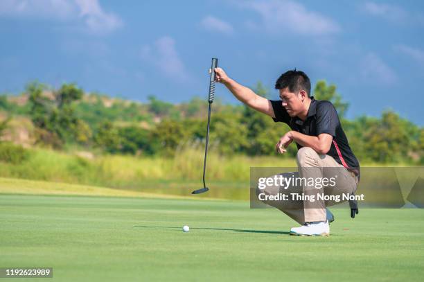 man preparing to putt on golf course - golfer putting stock pictures, royalty-free photos & images