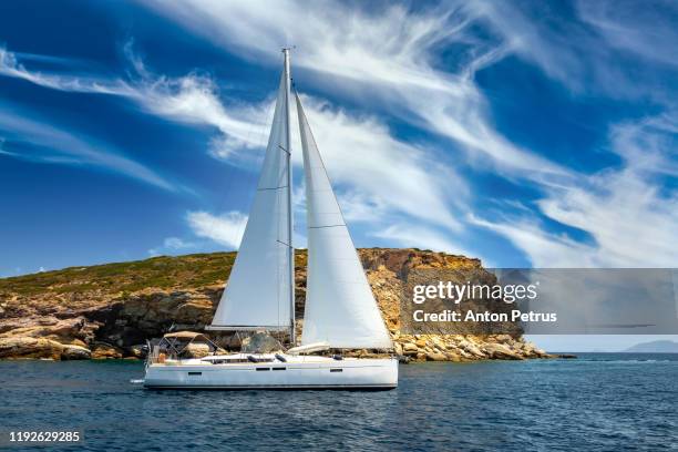 lonely yacht with white sails in the sea on a background of beautiful clouds. summer vacation - sea ​​of ​​clouds stockfoto's en -beelden