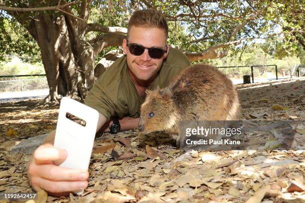 Lockie Ferguson of the New Zealand Test team takes a selfie with a Quokka during a visit to Rottnest Island on December 08, 2019 in Perth, Australia.