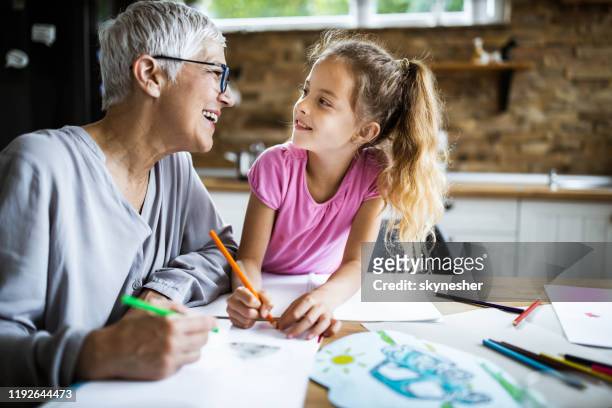 happy grandmother coloring with her granddaughter at home. - coloring stock pictures, royalty-free photos & images