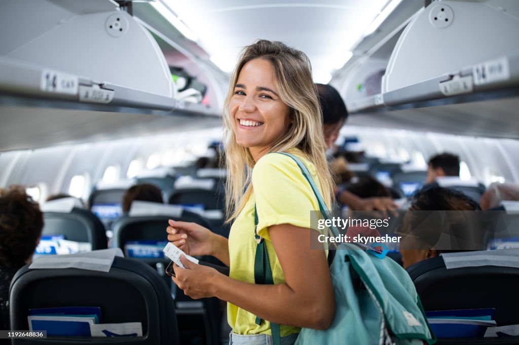 Junge glückliche Frau in einer Flugzeugkabine.