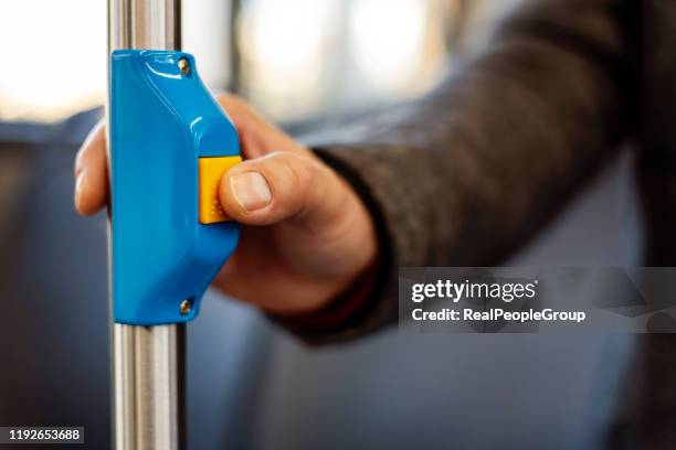 mann drückt den stoppknopf im stadtbus - busstop stock-fotos und bilder