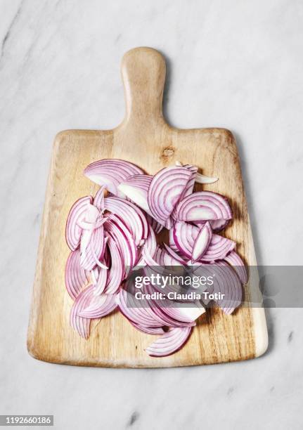 sliced red onion on wooden cutting board on white background - cutting red onion stock pictures, royalty-free photos & images