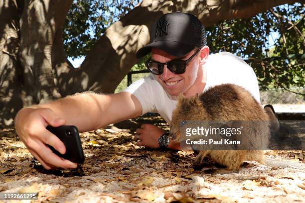 Tom Latham of the New Zealand Test team takes a selfie with a Quokka during a visit to Rottnest Island on December 08, 2019 in Perth, Australia.