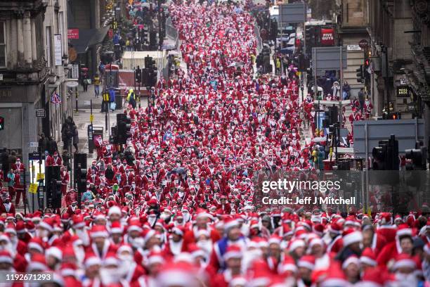 Thousands of members of the public dressed in Santa suits make their way through the streets on December 8, 2019 in Glasgow. The annual 5k fun run...