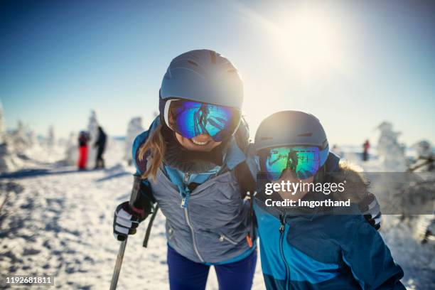 mutter und sohn beim skifahren an schönem sonnigen wintertag - family in snow mountain stock-fotos und bilder