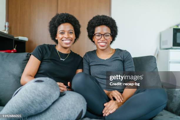 portret van jonge zwarte tweeling zusters - adult twins stockfoto's en -beelden