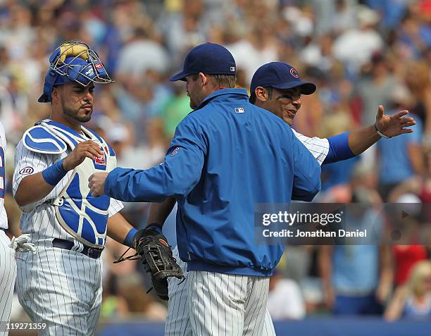 Ryan Dempster of the Chicago Cubs is congratulated by teammates Geovany Soto and Carlos Pena after a win over the Florida Marlins at Wrigley Field on...