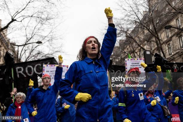 Group of feminist protesters march in blue boiler suits during a day of protest and ongoing transport worker strikes over French pension reform plans...