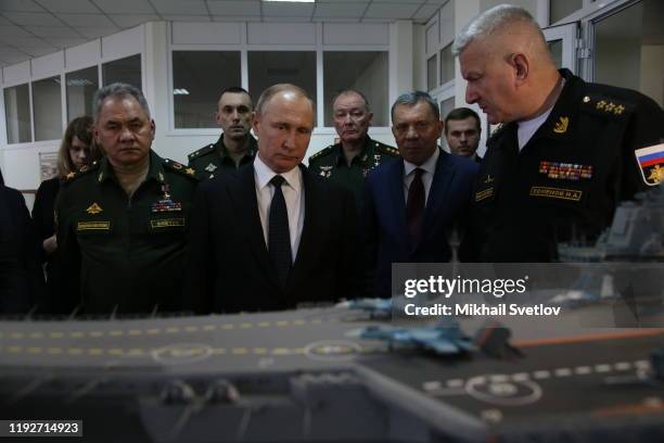 Russian President Vladimir Putin observes a layout of Russian aircraft carrier Admiral Kuznetsov while visiting a military expositionon January 9,...