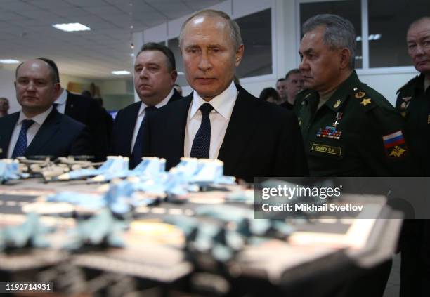 Russian President Vladimir Putin observes a layout of Russian aircraft carrier Admiral Kuznetsov while visiting a military expositionon January 9,...