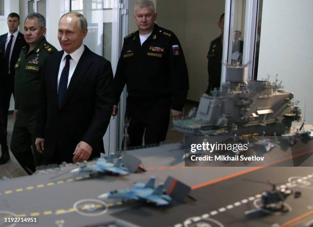 Russian President Vladimir Putin observes a layout of Russian aircraft carrier Admiral Kuznetsov while visiting a military expositionon January 9,...