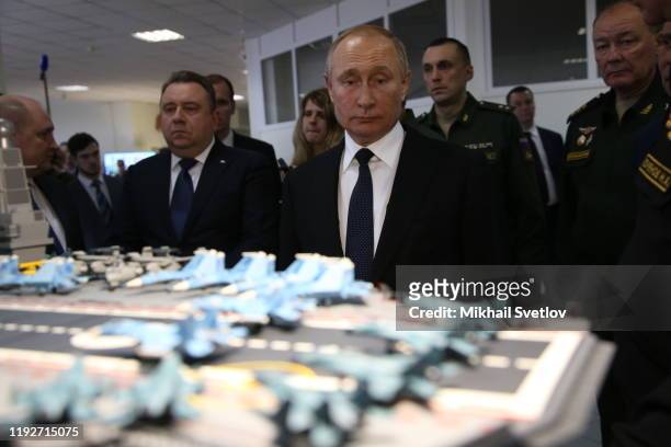 Russian President Vladimir Putin observes a layout of Russian aircraft carrier Admiral Kuznetsov while visiting a military expositionon January 9,...
