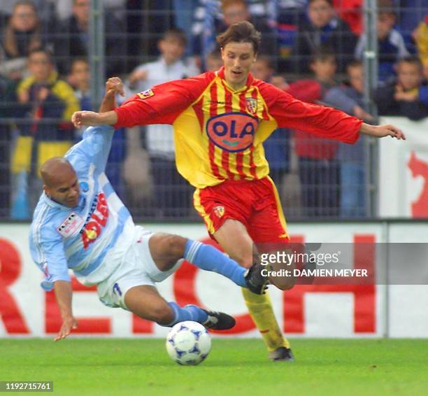 Le Strasbourgeois Dauphine Collet , tente de tacler le Lensois Yoann Lachor , le 21 mai 1999 au stade de la Meinau à Strasbourg, lors du match...