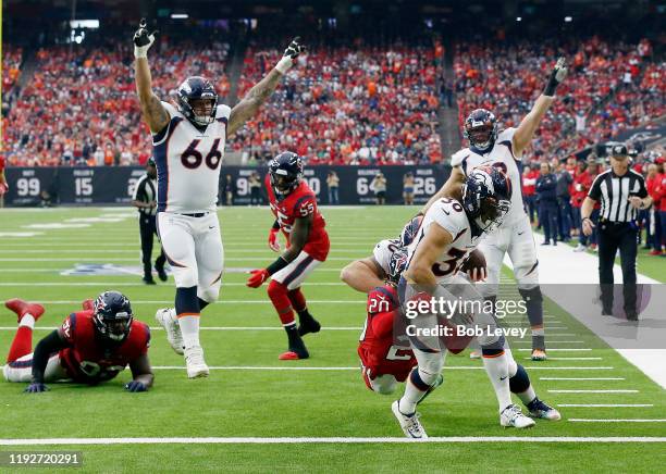 Phillip Lindsay of the Denver Broncos scores a touchdown as Justin Reid of the Houston Texans defends in the second quarter at NRG Stadium on...
