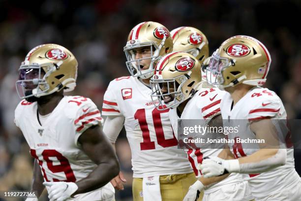 Raheem Mostert of the San Francisco 49ers celebrates with Jimmy Garoppolo after scoring a 10 yard touchdown against the New Orleans Saints during the...