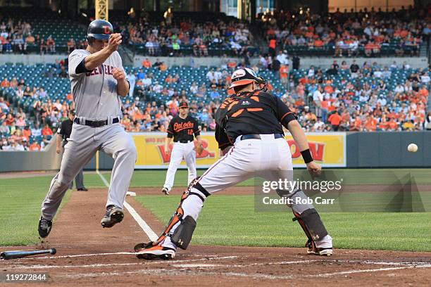 Grady Sizemore of the Cleveland Indians scores a run in front of catcher Matt Wieters of the Baltimore Orioles during the second inning at Oriole...