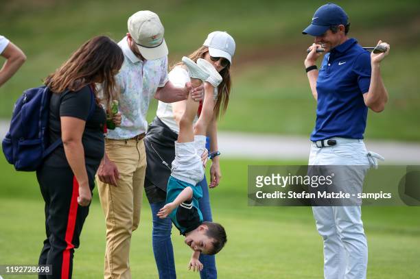 Justin Timberlake lifts up his son Silas next to his wife Jessica Biel and Rory McIlroy of Northern Ireland ahead of the Pro-Am prior to the start of...