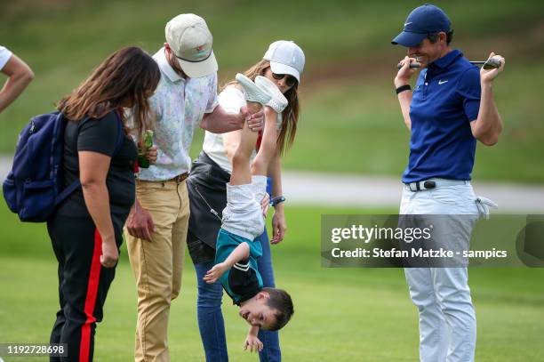 Justin Timberlake lifts up his son Silas next to his wife Jessica Biel and Rory McIlroy of Northern Ireland ahead of the Pro-Am prior to the start of...