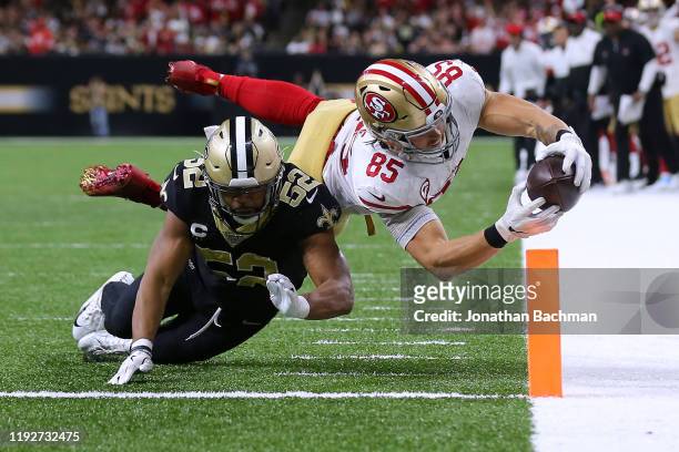George Kittle of the San Francisco 49ers scores a touchdown as Craig Robertson of the New Orleans Saints defends during the second half of a game at...